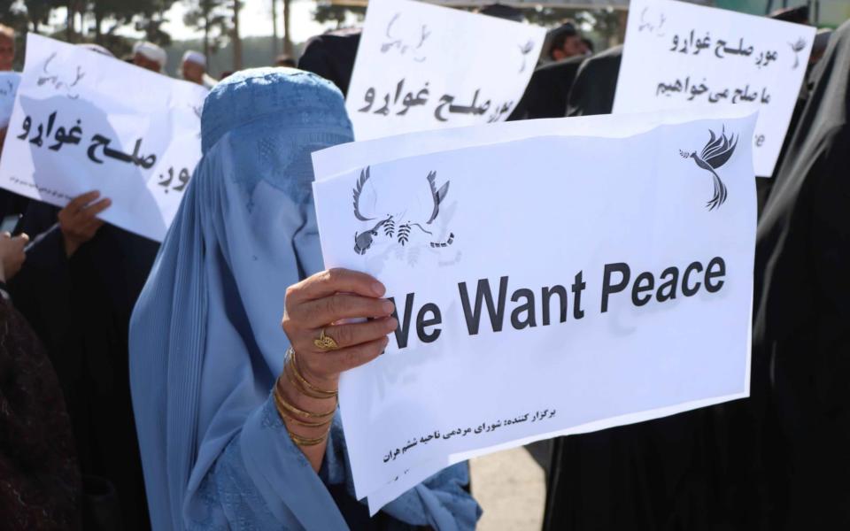 Afghans hold placards as they rally to support the Doha peace talks between Taliban and the Afghan government, in Herat, Afghanistan - JALIL REZAYEE/EPA-EFE/Shutterstock 