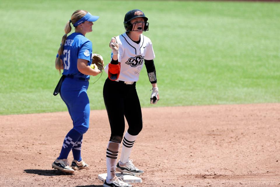 Oklahoma State infielder Claire Timm (18) celebrates beside Kentucky infielder Erin Coffel (21) at second base after hitting a double in the third inning of a softball game between the Oklahoma State Cowgirls and Kentucky in the Stillwater Regional of the NCAA Tournament, Saturday, May 18, 2024. Oklahoma State won 6-2.