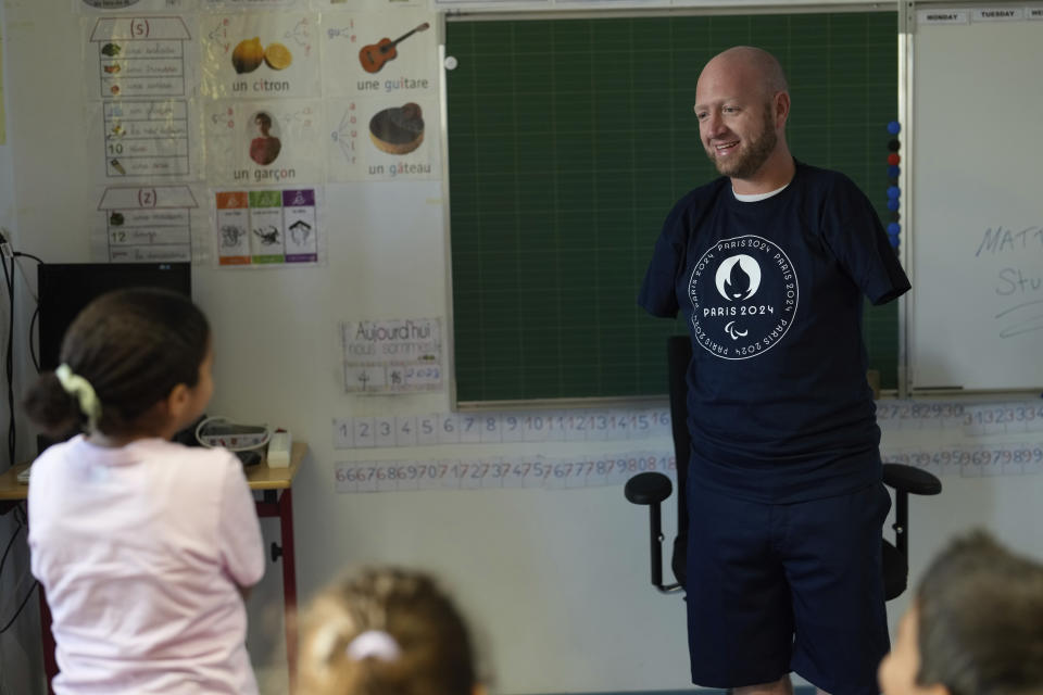 Archer Matt Stutzman of United States talks to a pupil during a visit in a Paris school, in Paris, Wednesday, Oct. 4, 2023. Visiting France's capital before Paralympic tickets go on sale next week, Stutzman dropped by a Paris school on Wednesday and wowed its young pupils with his shooting skills. (AP Photo/Thibault Camus)