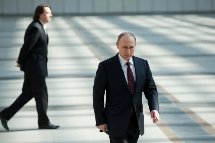 A men is seen walking forward, while another man crosses behind him.