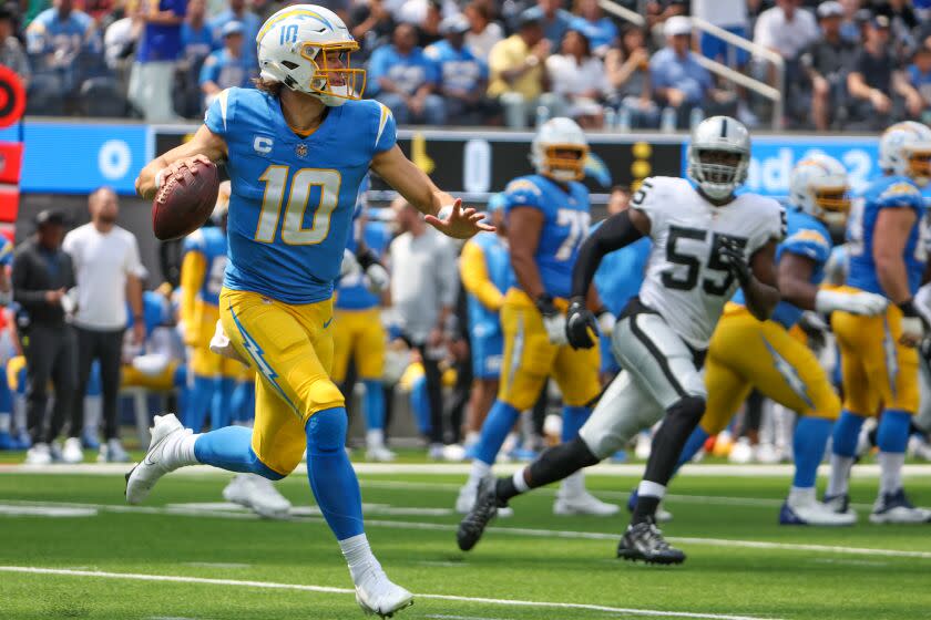 Chargers quarterback Justin Herbert rolls out to pass against the Las Vegas Raiders