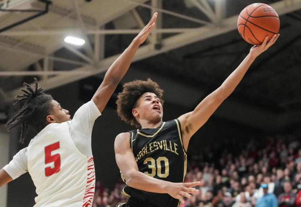 Noblesville Millers guard Baron Walker (30) goes in for a lay-up against Fishers Tigers Jason Gardner (5) on Saturday, March 2, 2024, during the Class 4A sectional final at Noblesville High School in Noblesville. The Fishers Tigers defeated the Noblesville Millers, 49-47.