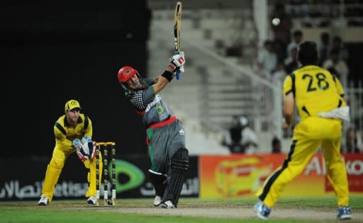 Afghanistan's batsman Mohammad Nabi (C) hits a six as Australian wicketkeeper Matthew Wade (L) looks on during an One Day International cricket match at the Sharjah cricket stadium. Former world champions Australia defeated a battling Afghanistan team by 66 runs in the first-ever limited overs international between the two sides