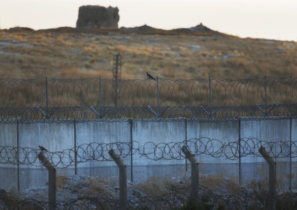 In this photo taken from the Turkish side of the border between Turkey and Syria, barbed wire and fences form the border, in Akcakale, Sanliurfa province, southeastern Turkey, Tuesday, Oct. 8, 2019. The Turkey - Syria border has became a hot spot as Turkish Vice President Fuat Oktay said Turkey was intent on combatting the threat of Syrian Kurdish fighters across its border in Syria.(AP Photo/Lefteris Pitarakis)