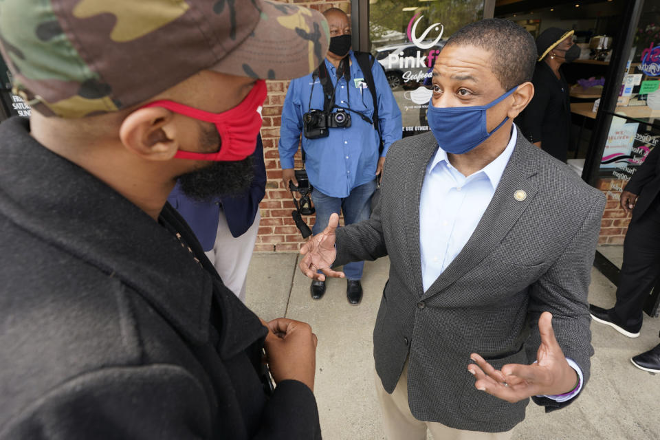 Virginia Democratic gubernatorial candidate Lt. Gov. Justin Fairfax, right, speaks to a supporter outside Pink Fish restaurant in Hampton, Va., Thursday, April 8, 2021. Fairfax has long had lofty political ambitions, and despite facing two unresolved allegations of sexual assault he’s pressing forward with a bid for governor. (AP Photo/Steve Helber)