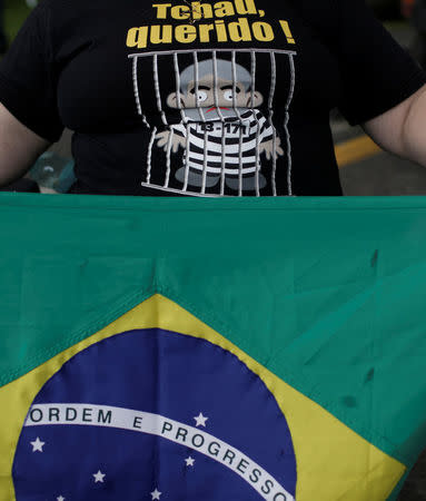 A demonstrator wears a T-shirt with an image depicting the former Brazilian President Luiz Inacio Lula da Silva in front of the Federal Police headquarters, where Lula was sentenced to serve a 12-year prison sentence for corruption, in Curitiba, Brazil April 6, 2018. The t-shirt reads: "Bye, dear!". REUTERS/Ricardo Moraes