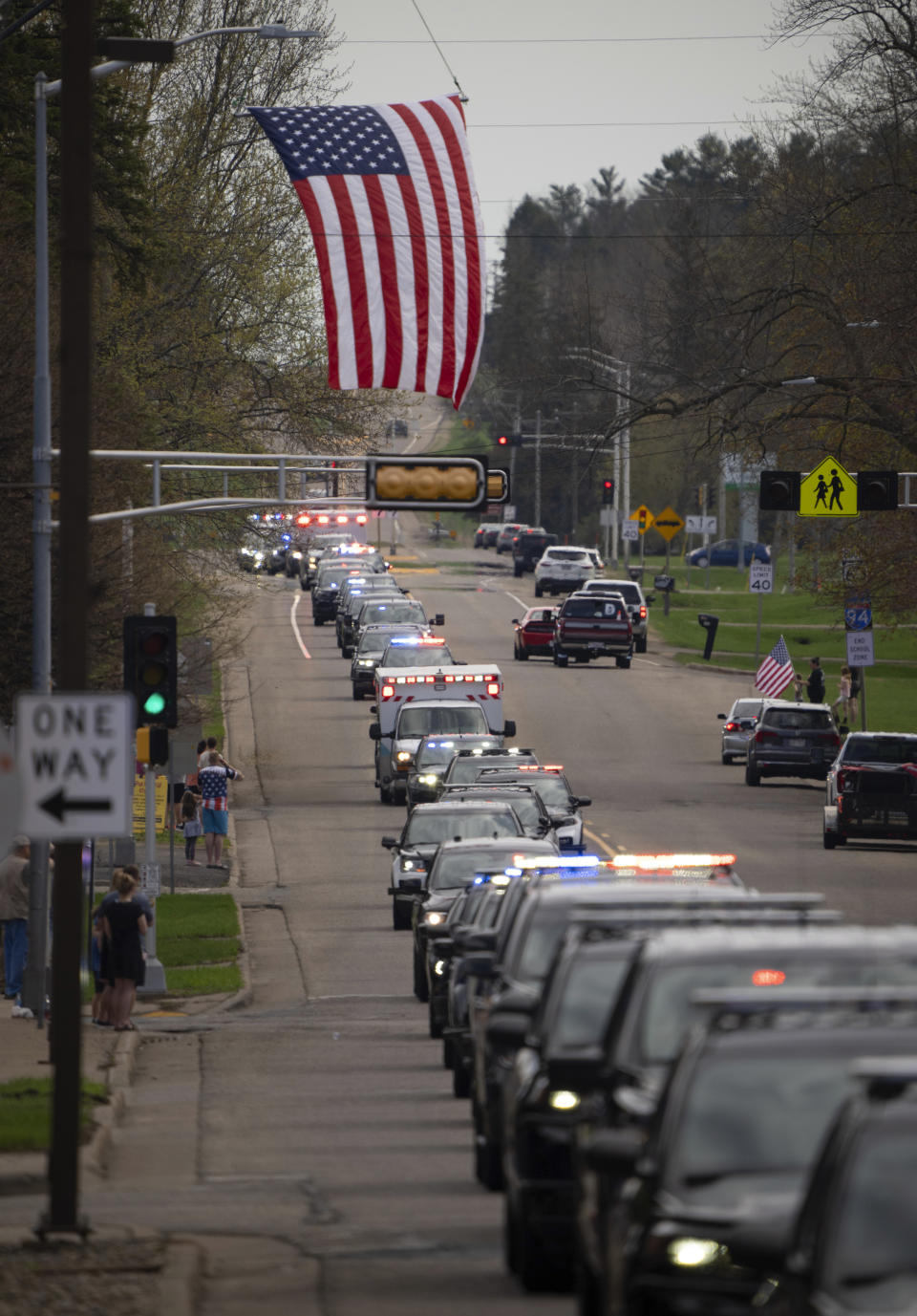 A procession of dozens of law enforcement vehicles follow the vehicle carrying St. Croix County Deputy Kaitie Leising's body near a Baldwin, Wis., funeral home Sunday afternoon, May 7, 2023. Leising was shot and killed during a traffic stop Saturday. (Jeff Wheeler/Star Tribune via AP)