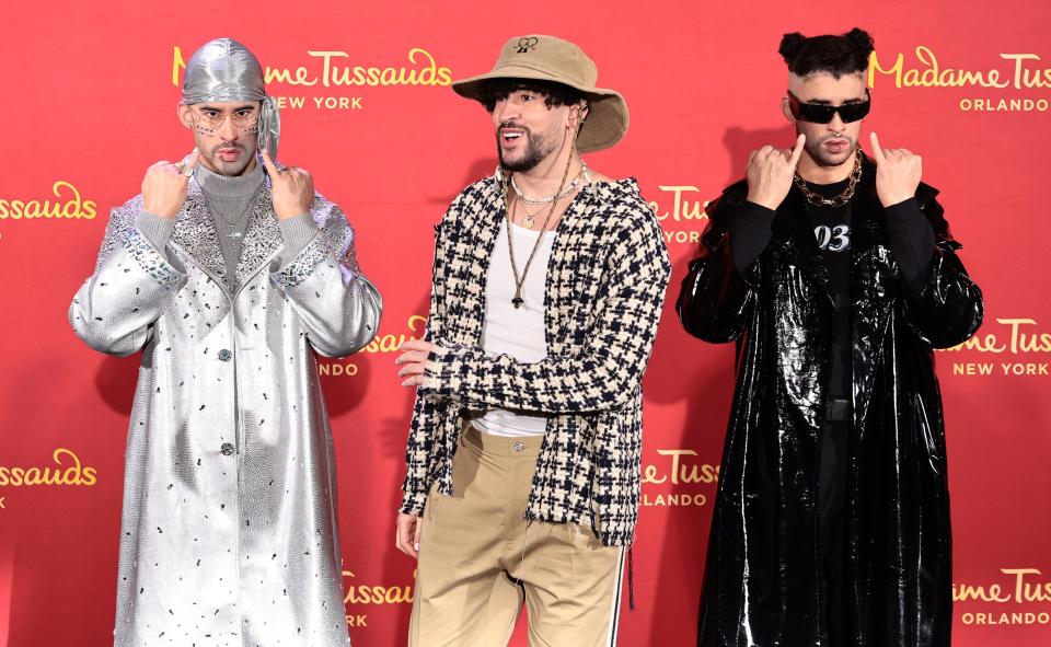 Bad Bunny (center) standing between two of his wax figures at Madame Tussauds New York in April 2022.