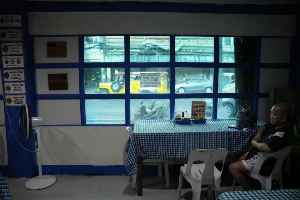 A woman waits inside the American Legion Post 4 just outside what used to be America's largest overseas naval base at Olongapo city, Zambales province, northwest of Manila, Philippines on Monday Feb. 6, 2023. The U.S. has been rebuilding its military might in the Philippines after more than 30 years and reinforcing an arc of military alliances in Asia in a starkly different post-Cold War era when the perceived new regional threat is an increasingly belligerent China. (AP Photo/Aaron Favila)