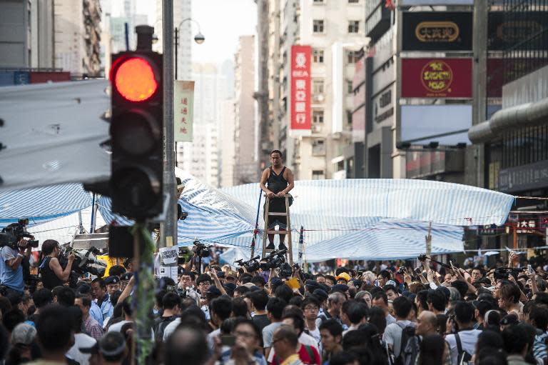 A man climbs a ladder at the site of a pro-democracy protest in Mongkok district, Hong Kong, on October 6, 2014