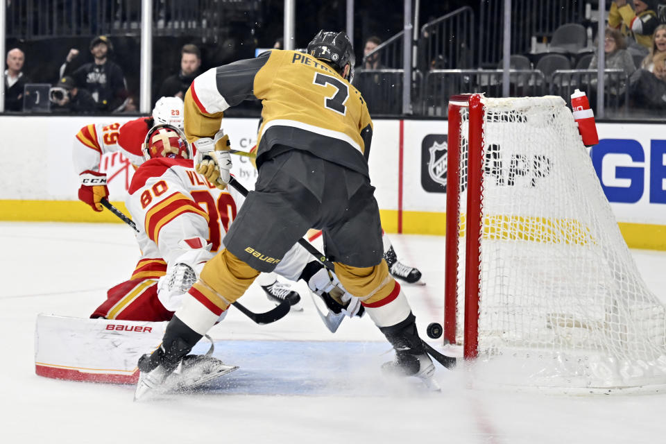 Vegas Golden Knights defenseman Alex Pietrangelo (7) scores against Calgary Flames goaltender Dan Vladar (80) during overtime of an NHL hockey game Thursday, Feb. 23, 2023, in Las Vegas. (AP Photo/David Becker)