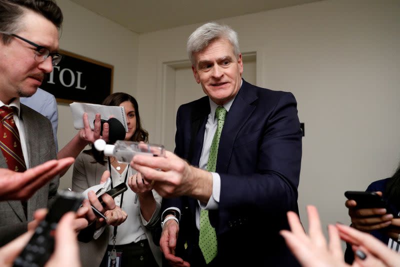 FILE PHOTO: U.S. Senator Bill Cassidy (R-LA) gives news reporters hand sanitizer following a Senate hearing on the COVID-19 Coronavirus, on Capitol Hill in Washington