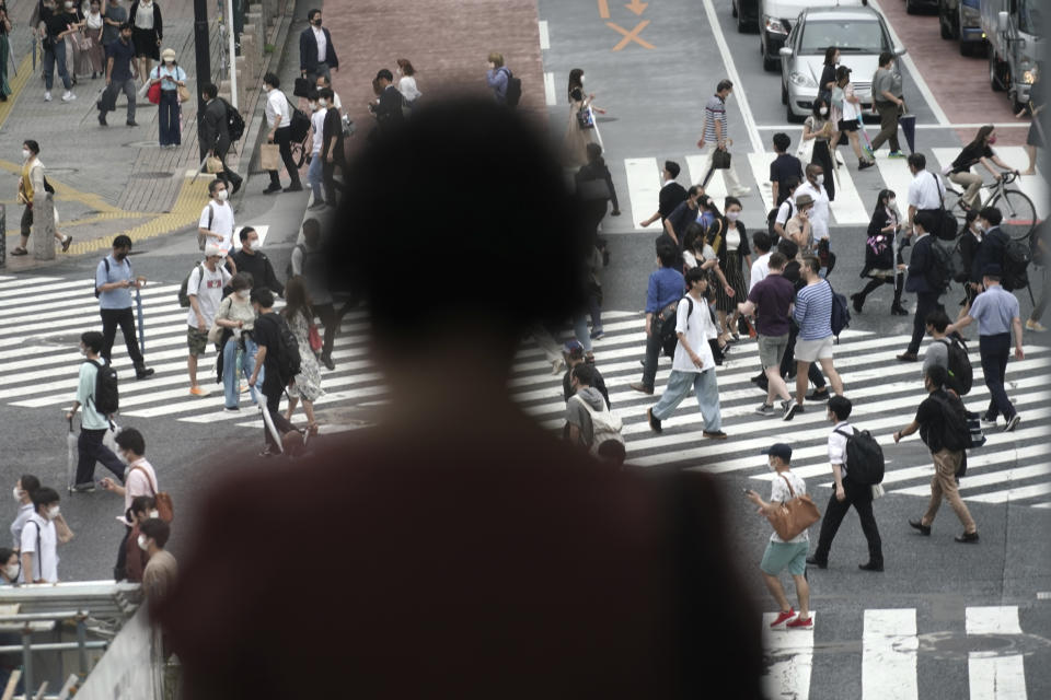 People wearing a protective face mask to help curb the spread of the coronavirus walk at Shibuya pedestrian crossing Thursday, July 9, 2020, in Tokyo. The Japanese capital has confirmed more than 220 new coronavirus infections, exceeding its previous record.(AP Photo/Eugene Hoshiko)