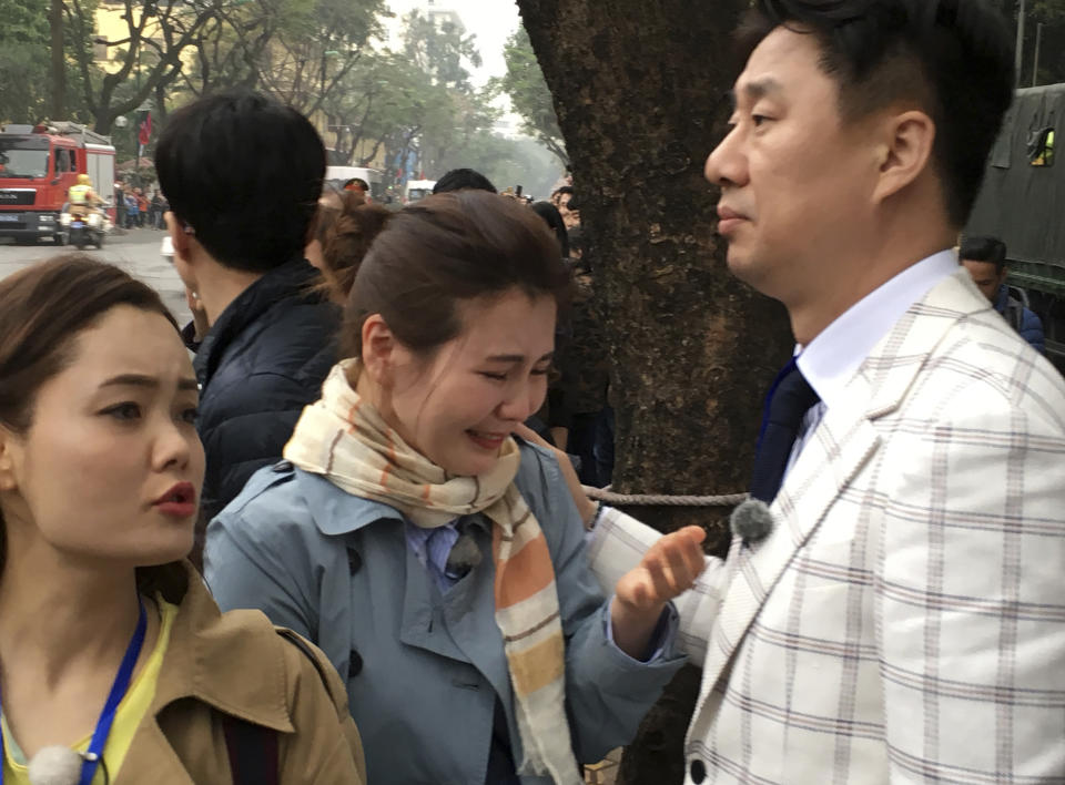 North Korean defector Shin Eun Ha, center, cries after a limousine carrying North Korean leader Kim Jong Un passes by her near a Hanoi hotel where Kim is staying, Tuesday, Feb. 26, 2019, in Hanoi, Vietnam. Nam Hee Seok, a South Korean TV talk show on North Korea, right, who is patting the back of Shin, who is a regular guest on the program. On left is another North Korean defector who appears on the program. Shin and another North Korean defector have flown to Hanoi to wish for progress during the second summit between their former leader Kim Jong Un and Trump. (AP Photo Kim Hyung-jin)