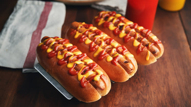 three hot dogs with ketchup and mustard