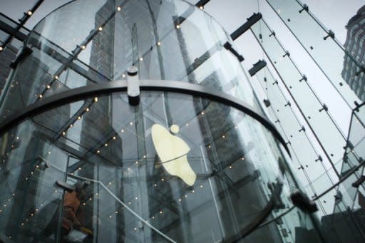 The Apple logo is illuminated at the entrance to an Apple Store May 23, 2011 in New York City. In July, corporate giants such as 3M, Caterpillar, Goodyear, Microsoft and Apple reported blockbuster results though the stock market still slumped amid fears of an economic slowdown and a possible government default