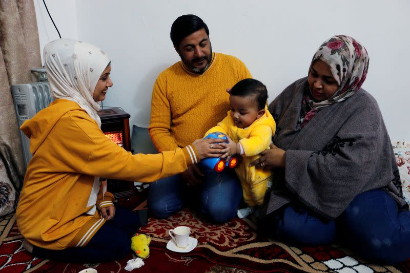 Jassem, 24, an Iraqi nurse sits with her family at home in Baghdad