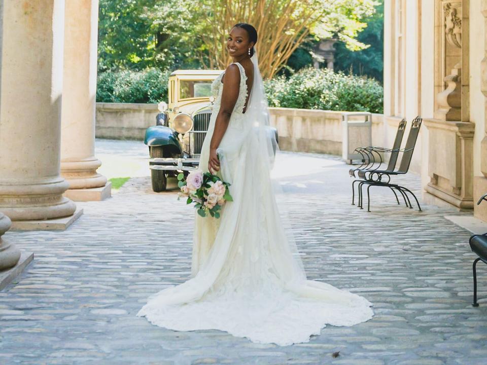 A bride looks over her shoulder in her wedding dress.