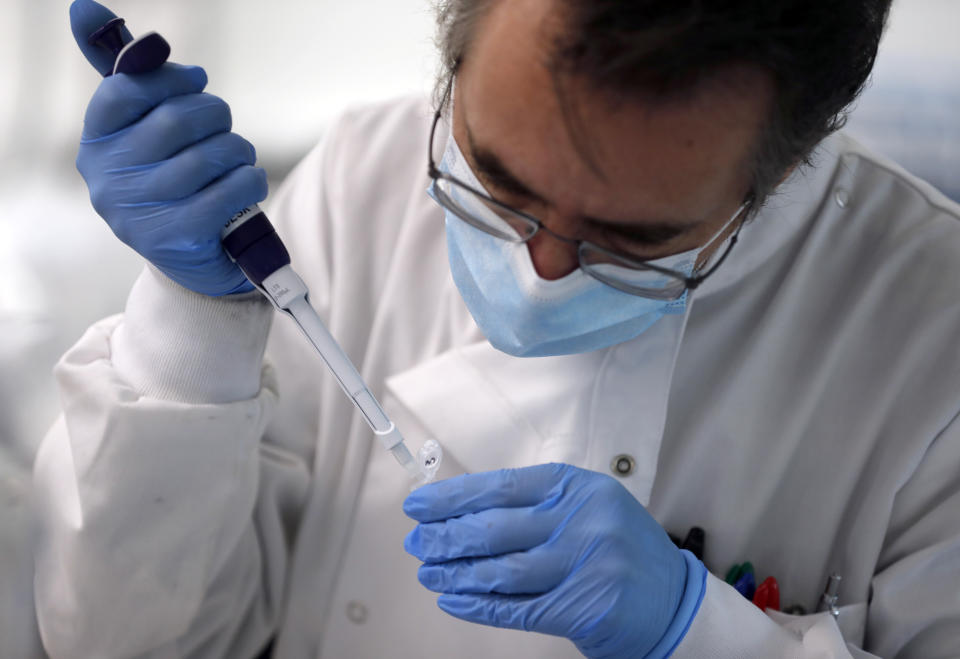 A lab assistant uses a pipette to prepare Coronavirus RNA for sequencing at the Wellcome Sanger Institute that is operated by Genome Research in Cambridge, Thursday, March 4, 2021. Cambridge University microbiologist Sharon Peacock understood that genomic sequencing would be crucial in tracking the coronavirus, controlling outbreaks and developing vaccines, so she began working with colleagues around the country to put together a plan when there were just 84 confirmed cases in the country. The initiative helped make Britain a world leader in rapidly analyzing the genetic material from large numbers of COVID-19 infections, generating more than 40% of the genomic sequences identified to date.(AP Photo/Frank Augstein)