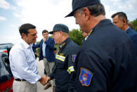 Greek Prime Minister Alexis Tsipras meets with firefighters as a wildfire is being contained after four days near the village of Kapandriti, north of Athens, Greece August 16, 2017. REUTERS/Murad Sezer