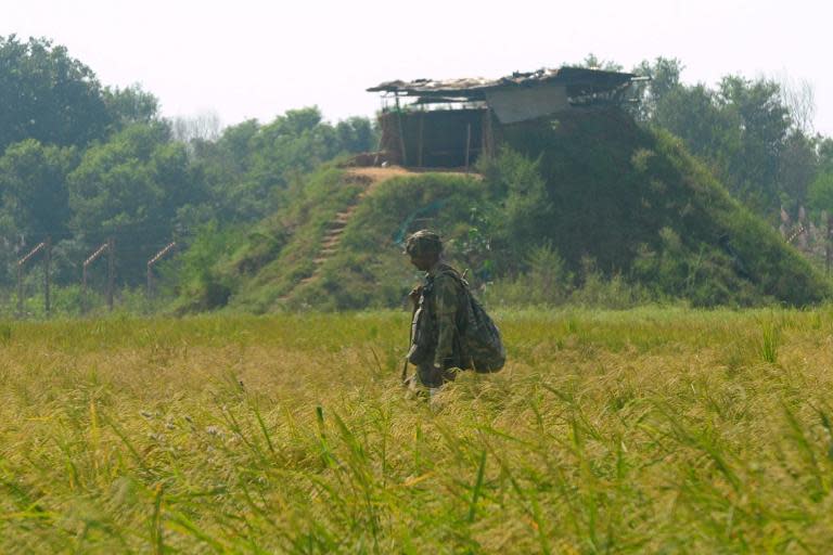 An Indian soldier keep watch following cross-border firing between Pakistan and Indian troops at Chachwal, on October 11, 2014