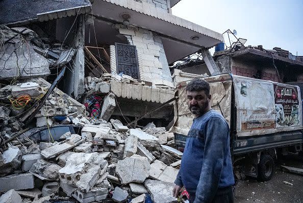 A resident stands in front of  a collapsed building following an earthquake in the town of Jandaris, in the countryside of Syria's northwestern city of Afrin in the rebel-held part of Aleppo province, on February 6, 2023. - Hundreds have been reportedly killed in north Syria after a 7.8-magnitude earthquake that originated in Turkey and was felt across neighbouring countries. (Photo by Rami al SAYED / AFP) (Photo by RAMI AL SAYED/AFP via Getty Images)