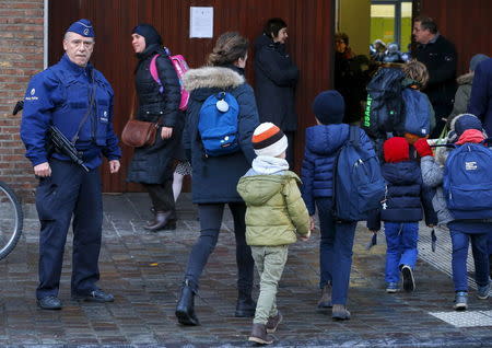 A Belgian police officer stands guard outside a school in central Brussels November 25, 2015. Brussels' schools re-opened on Wednesday after staying closed for two days following tight security measures linked to the fatal attacks in Paris. REUTERS/Yves Herman -