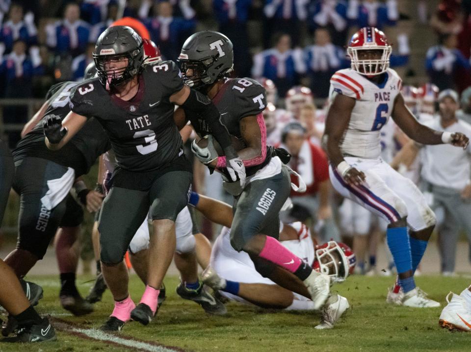 Tate's Edward O'Brien (No. 3) provides the block so running back Andre Colston (No. 18) can slip past the Pace defense during Friday night's district matchup.