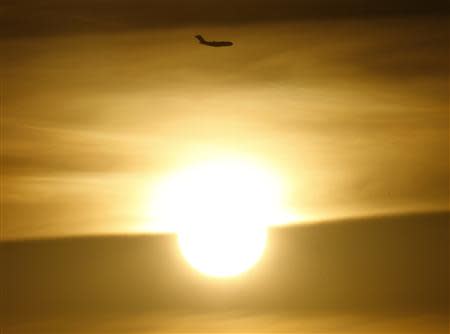 An Australian Air Force C-17 Globemaster aircraft flies above the sun as it prepares to land at the RAAF Base Pearce near Perth, March 28, 2014. REUTERS/Jason Reed