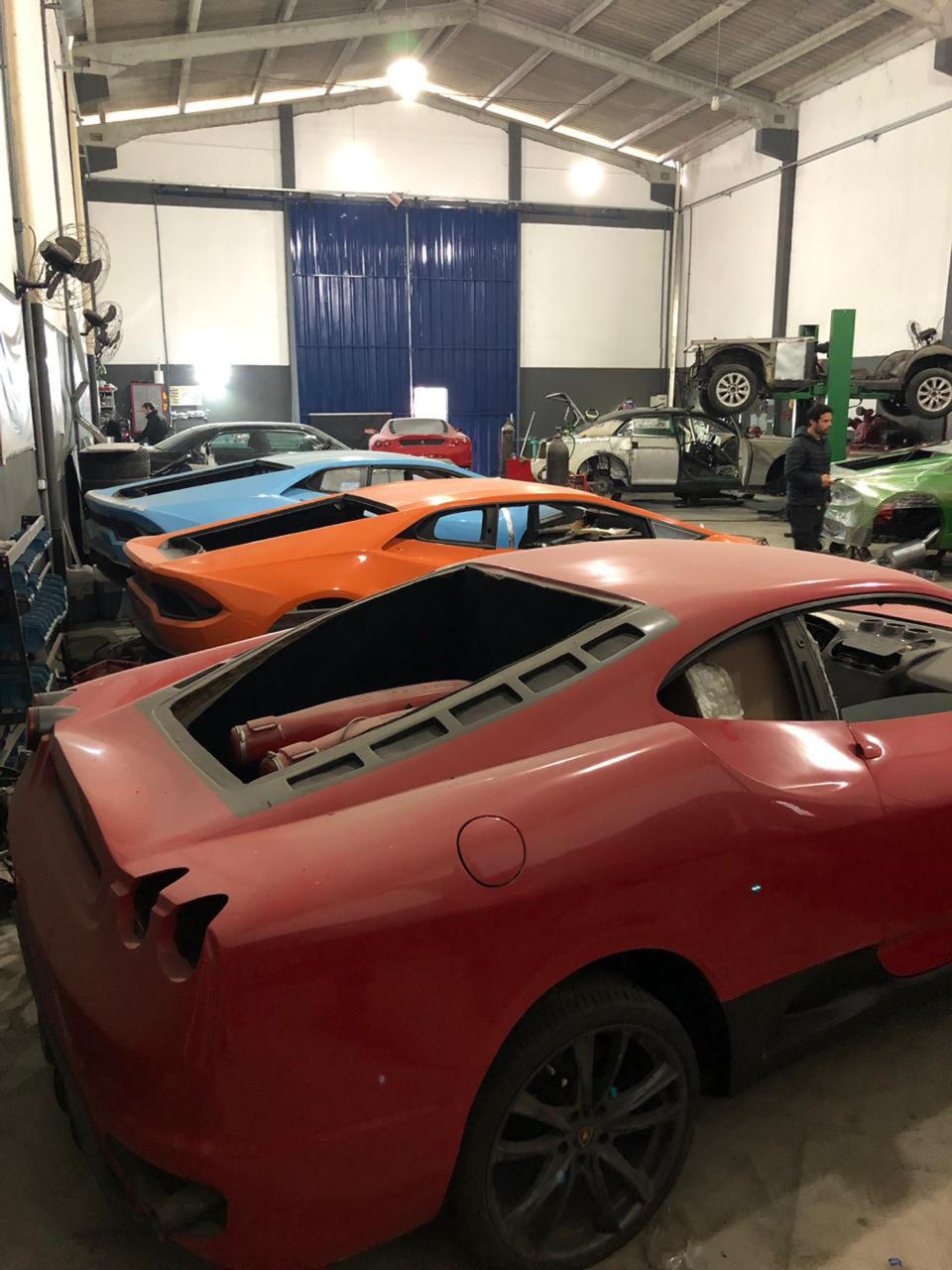 This July 15, 2019 photo released by Itajai Civil Police shows luxury car replicas inside a workshop in Itajai, Brazil. Brazilian police dismantled the clandestine workshop run by a father and son who assembled fake Ferraris and Lamborghinis to order, in Brazil's southern state of Santa Catarina. (Itajai Civil Police via AP)