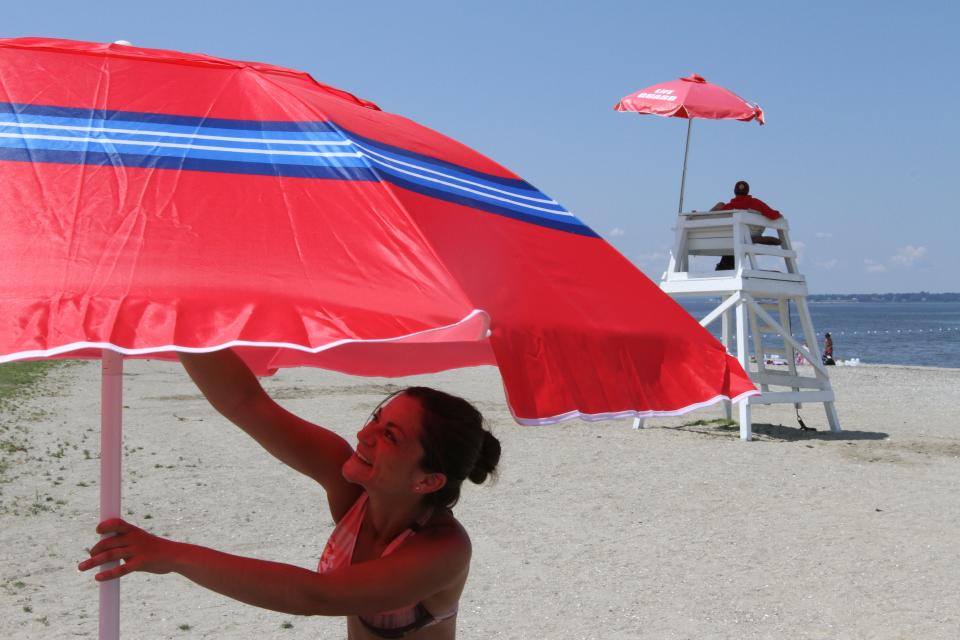 Jessica Roderigues raises her umbrella as she and her son Ethan spend the day at Bristol Town Beach.  "I love it here, there's so much you can do, with all the tennis and volleyball courts, and the sheltered dining area, and the water is calm--great for swimming," she says. She says she comes here often from her hometown of Fall River.