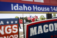 Robert Koellisch holds an American flag in front of political signs for Idaho's Primary Election in Eagle, Idaho, Tuesday, May 17, 2022. (AP Photo/Kyle Green)