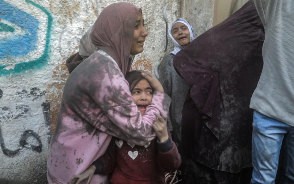 Palestinian girls cry following an Israeli air strike