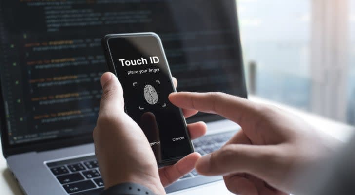 a person holding a phone with a touch id app displayed on it