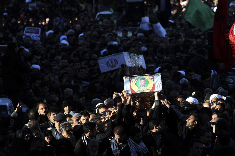 Mourners carry flag-draped caskets during a mass funeral for those killed in a suicide car bombing that targeted members of Iran's powerful Revolutionary Guard in earlier in the week, killing at least 27 people, in Isfahan, Iran, Saturday, Feb. 16, 2019. The head of the Guard has threatened to retaliate against neighboring Saudi Arabia and United Arab Emirates over the bombing. (AP Photo/Ebrahim Noroozi)