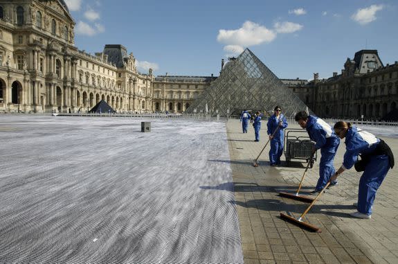 Volunteer workers help set up the giant photographic work.