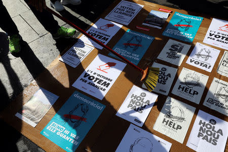 People paste posters on a cardboard in support of the banned October 1st independence referendum in Barcelona, Spain, September 24, 2017. REUTERS/Susana Vera