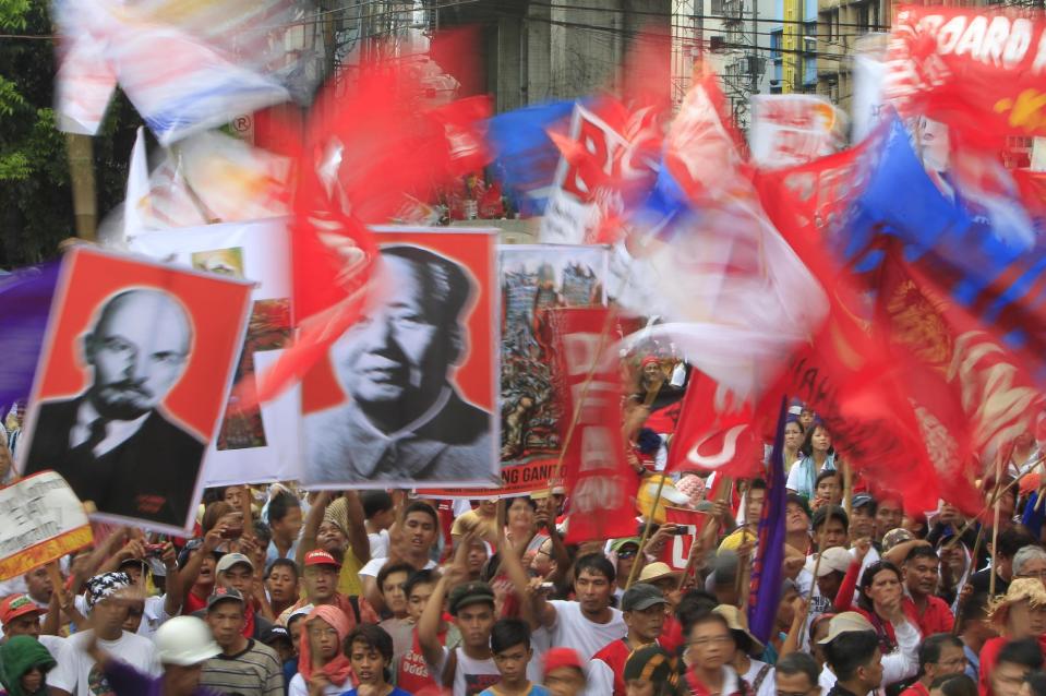 Protesters wave banners, including portraits of Russian Marxist revolutionary leader Vladimir Lenin, left, and Mao Tse-tung, founding father of the People's Republic of China, during a rally near the Presidential Palace in Manila to celebrate international Labor Day known as May Day Tuesday May 1, 2012 in the Philippines. (AP Photo/Bullit Marquez)