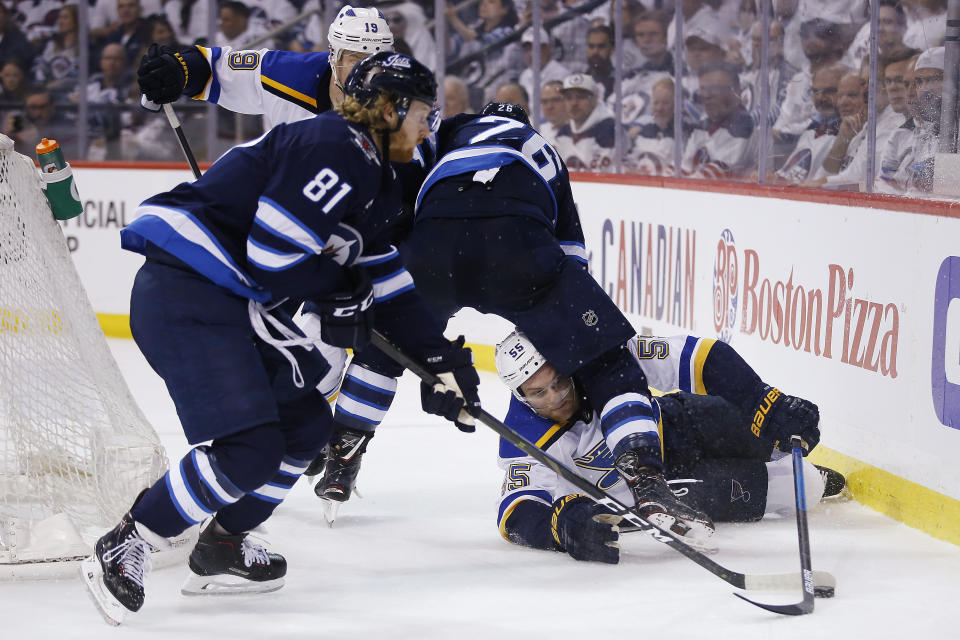 St. Louis Blues defenseman Colton Parayko (55) gets tangled up with Winnipeg Jets right wing Blake Wheeler (26) as Jets left wing Kyle Connor (81) picks up the loose puck during the second period of Game 5 of an NHL hockey first-round playoff series Thursday, April 18, 2019, in Winnipeg, Manitoba. (John Woods/The Canadian Press via AP)