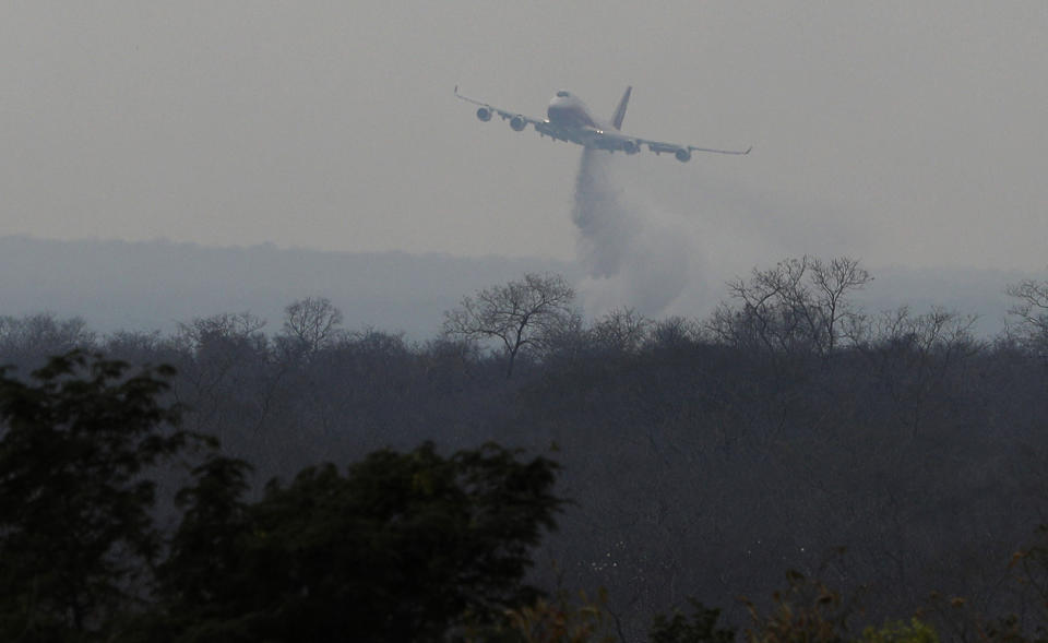 An airplane drops fire retardant on a wildfire burning in the ChiquitanÃ­a Forest near Robore, Bolivia, Sunday, Aug. 25, 2019. (Photo: Juan Karita/AP)