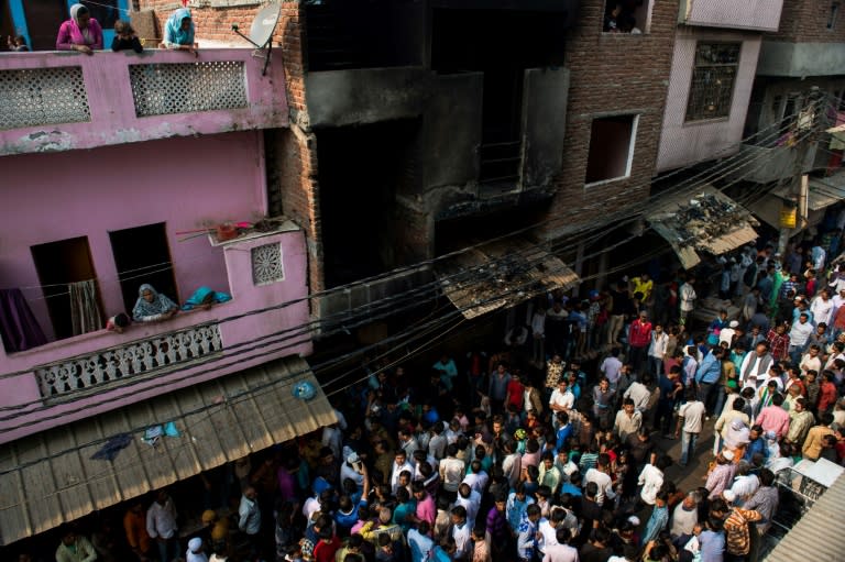 Residents gather near a gutted workshop in Ghaziabad, some 20 km east of New Delhi, on November 11, 2016