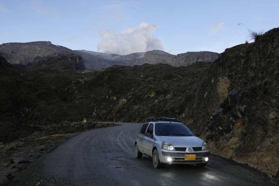 El volcán Nevado del Ruiz expulsa humo, al fondo en la cumbre, en una zona rural de Villahermosa, Colombia, el martes 11 de abril de 2023. Autoridades colombianas comenzaron a evacuar a algunas familias después de que el volcán mostrara un aumento de la actividad sísmica que apuntaba hacia una inminente erupción en los próximos días o semanas. (AP Foto/Fernando Vergara)