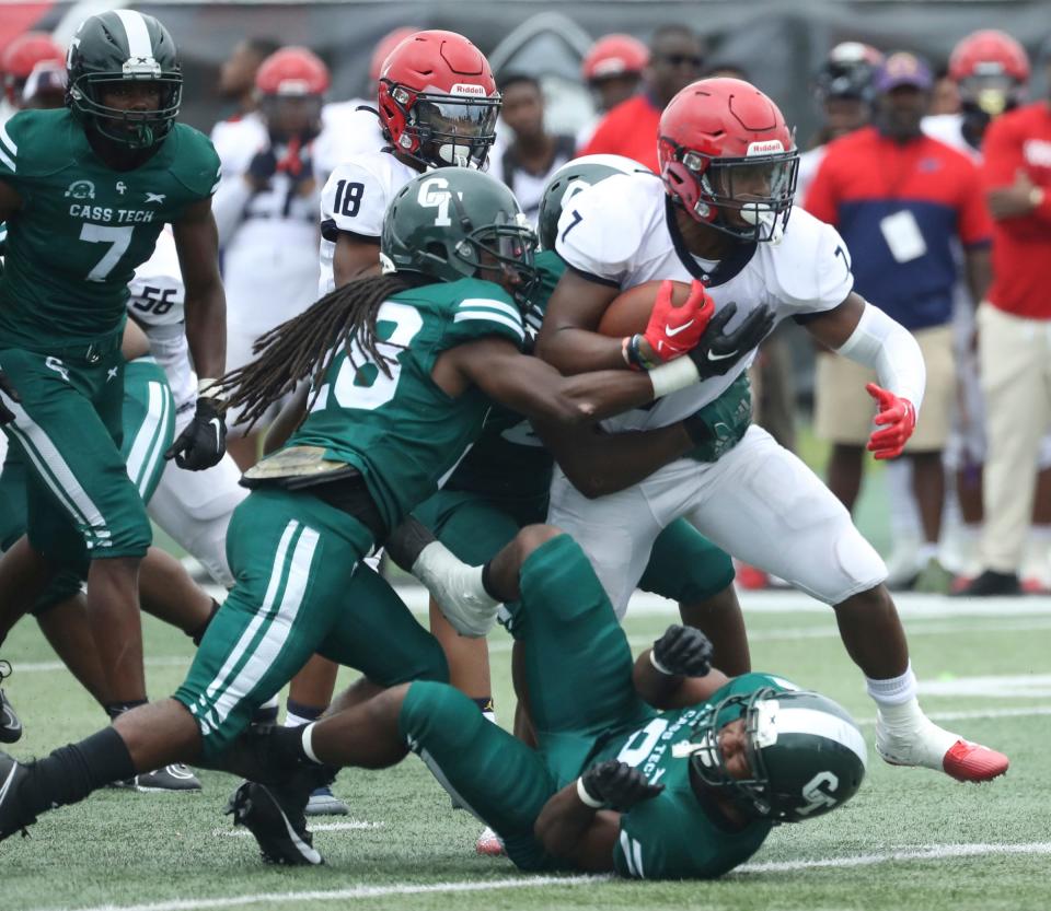 Southfield A&T Mathias Davis is tackled by Cass Tech defenders during first half action Saturday, August 26, 2023.