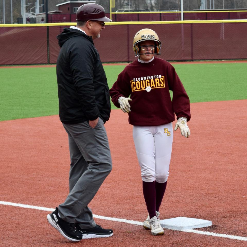 Bloomington North's Paris Stuffle chats with Cougars head coach Geoff Aiken after tagging up to advance to third base during North's game against Edgewood. (Seth Tow/Herald-Times)