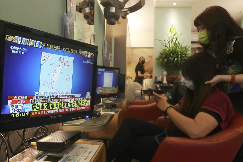 A TV news shows a map marking the areas where China is conducting live fire exercises near Taiwan, at a beauty salon in Taipei, Taiwan, Thursday, Aug 4, 2022. Taiwan canceled airline flights Thursday as the Chinese navy fired artillery near the island in retaliation for a top American lawmaker’s visit. (AP Photo/Chiang Ying-ying)