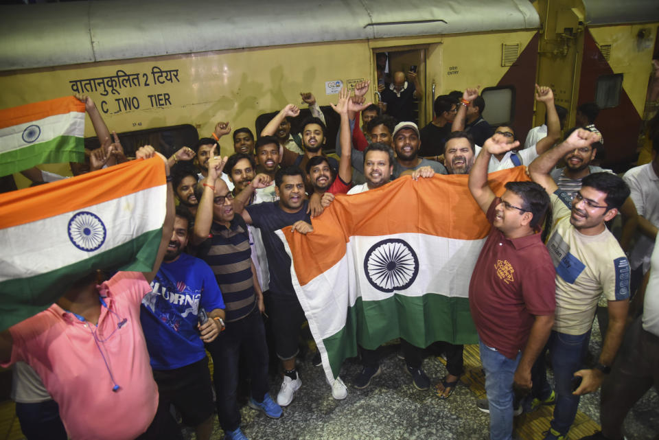 Indian cricket fans carrying national flags shout slogans as they board a special train run by Indian railways for Ahmadabad to ease huge rush for the Indian Pakistan cricket match during on going ICC Men's cricket World Cup, in Mumbai, India, Friday, Oct. 13, 2023. (AP Photo)