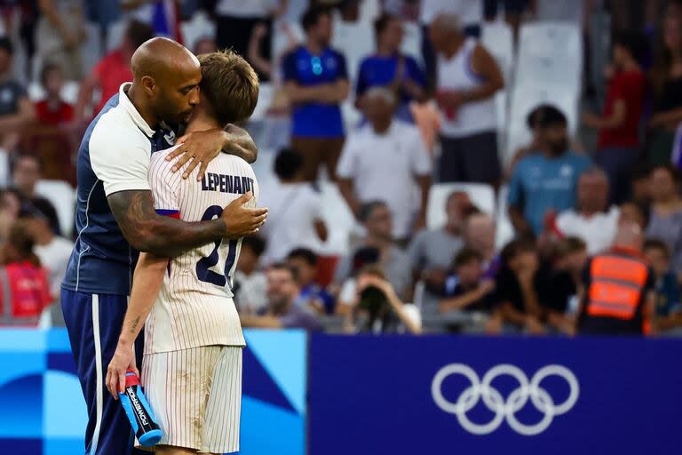 El DT Thierry Henry abraza al centrocampista Johann Lepenant al final de 3-0 de Francia sobre Nueva Zelanda, que permitió al local cerrar su grupo con el puntaje ideal.