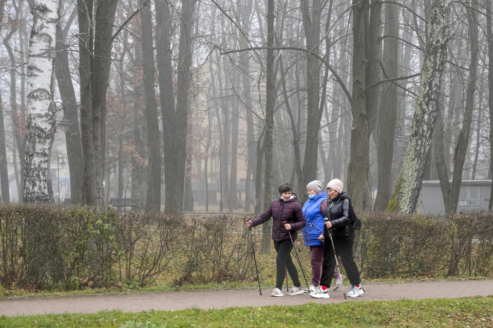 People enjoy Nordic walking in Morshyn, Ukraine, Wednesday, Nov. 17, 2021. In Morshyn, a scenic town nestled at the Carparthian foothills in the Lviv region, 74% of 3,439 residents have been fully vaccinated. A small spa town in western Ukraine stands out in a country where just under a quarter of the population has received coronavirus vaccines. (AP Photo/Efrem Lukatsky)