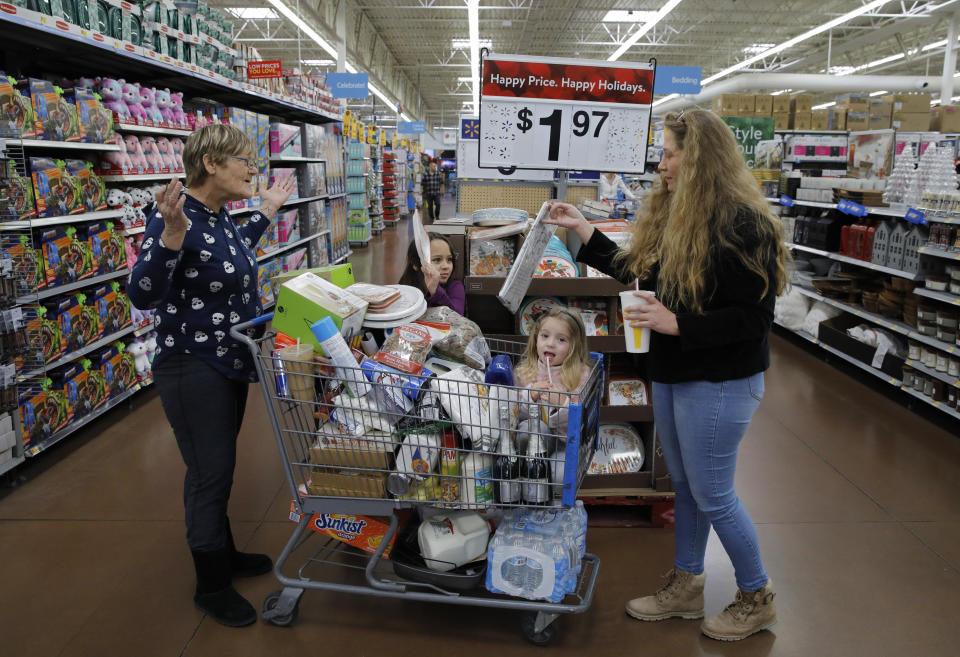 FILE - In this Nov. 27, 2019, file photo from left, Tina Fausto, left, and Olivia Wirtshafter, right, shop with Lilly Flores, second from left, and Laly Rose Stanton the day before the Thanksgiving holiday at a Walmart Supercenter in Las Vegas. On Wednesday, Dec. 11, the Labor Department reports on U.S. consumer prices for November. (AP Photo/John Locher, File)