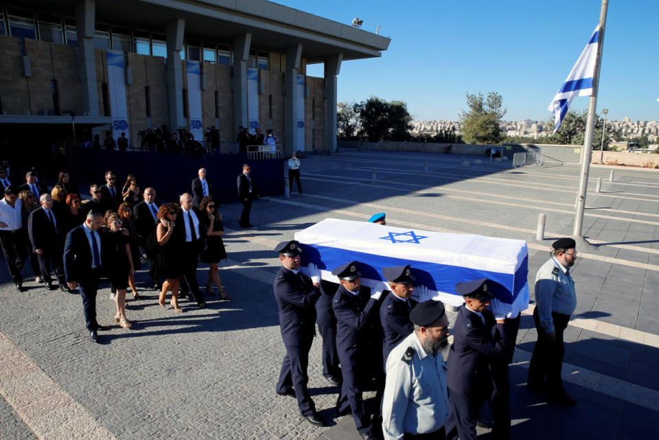 <p>Family members of former Israeli President Shimon Peres walk behind his flag-draped coffin carried during a ceremony at the Knesset, the Israeli parliament, before it is transported to Mount Herzl Cemetery ahead of the funeral in Jerusalem on Sept. 30, 2016. (REUTERS/Ammar Awad)</p>